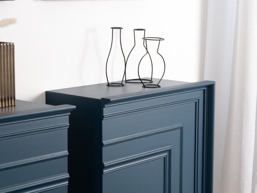 Madie laccate blu con pannellature a boiserie e vasi decorativi in metallo