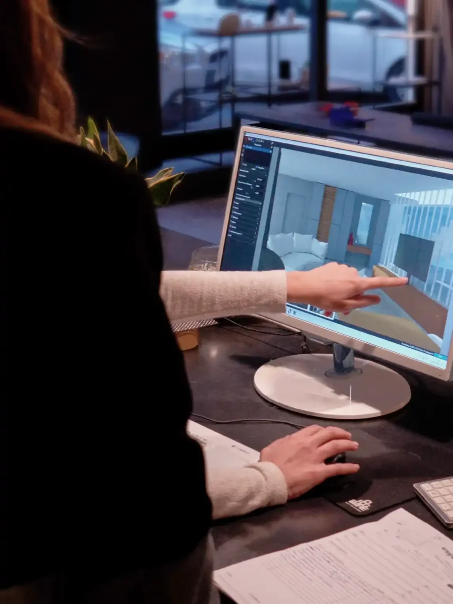Progettista che mostra al monitor il render 3D di un ambiente interno