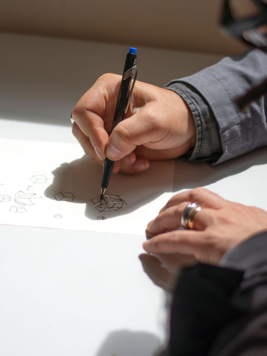 Mano che disegna uno schizzo di progetto con penna su foglio bianco