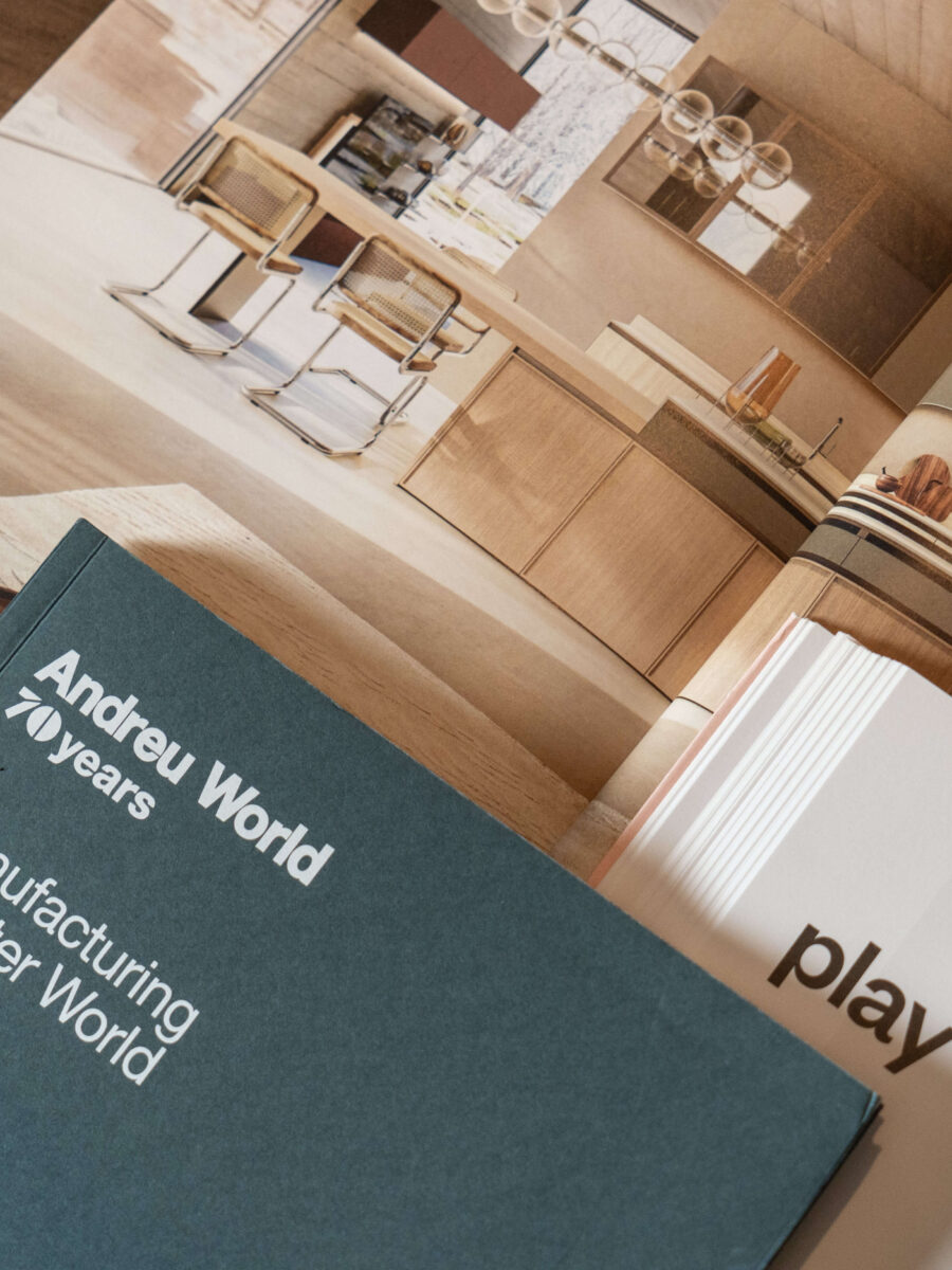 Catalogo Andreu World appoggiato su un tavolo, con ambienti di arredo sullo sfondo